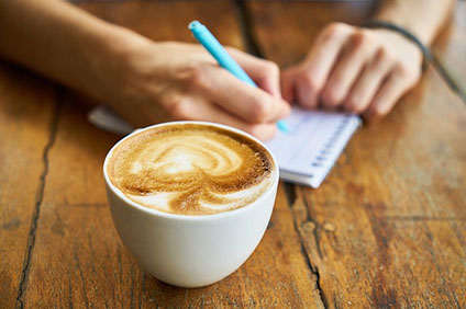 コーヒーとノートに何か書いているところ。